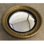 A vintage convex circular wall mirror with decorative gilt frame.