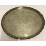 A hallmarked silver salver with engraving.