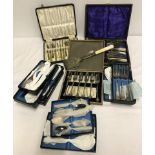 A quantity of vintage boxed epns cutlery sets together with a pair of asparagus tongs.