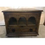 A small vintage dark wood TV cabinet with lift up glass fronted door and lower drawer.