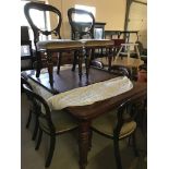 A large draw leaf table with brass clips and castors.