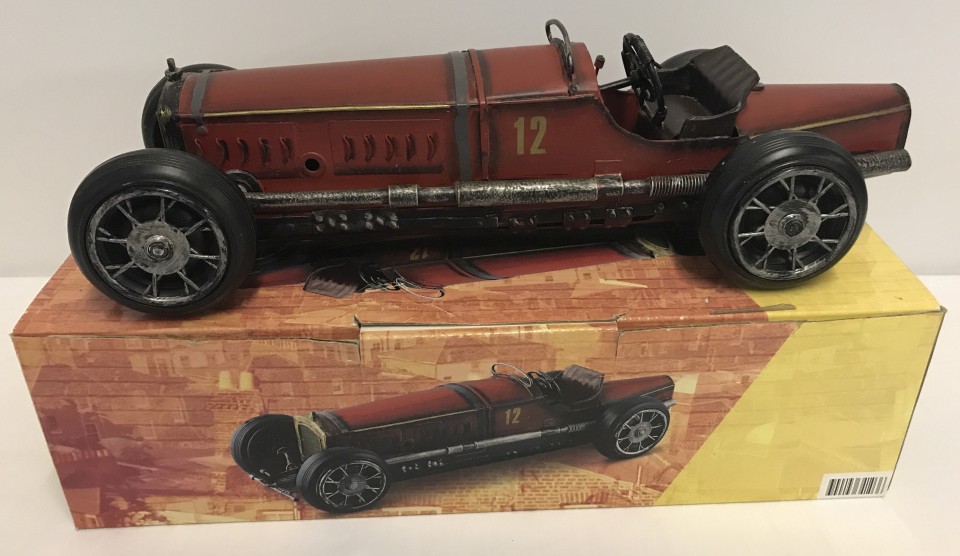A boxed tin plate model of a red Bugatti racing car.