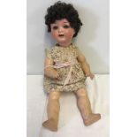 A vintage composite fully jointed doll with teeth and close eye action.