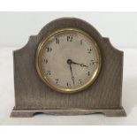 A 1920's silver free standing clock with engine turned decoration to front.