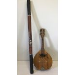 A vintage wooden Mandolin together with a Didgeridoo with tribal decoration.
