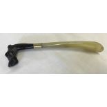 An early 20th century Italian shoe horn with dog's head handle and horn 'blade'.