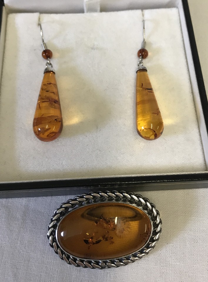 A pair of classic style amber drop earrings together with an oval amber brooch.