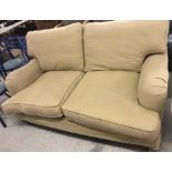 A vintage large two seater sofa with tan coloured removable covers.