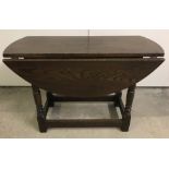 A small dark wood drop leaf table with turned legs.