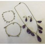 A silver necklace with 7 amethyst pendants and matching silver & amethyst earrings.