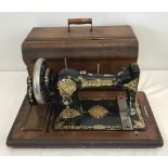 A vintage wooden cased Jones sewing machine with boxed accessories.