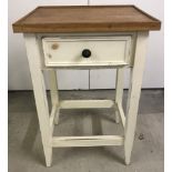 A small vintage single drawer side table with cream painted base and natural wood top.