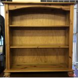 A modern pine bookcase with bun feet.