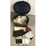 A tin hat box containing a quantity of ephemera and vintage leather purses.