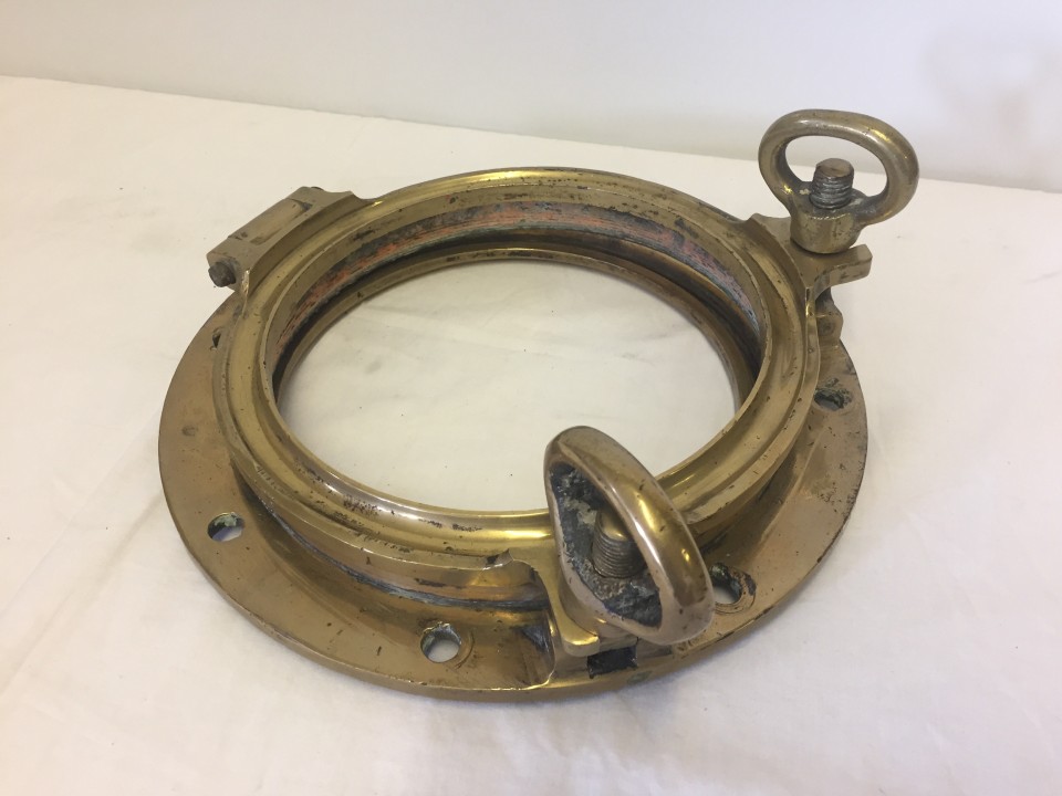 A heavy brass WWI-WWII porthole frame and cover. Glass missing.