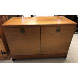 A modern low 2 door oak cupboard with interior shelf, on castors.