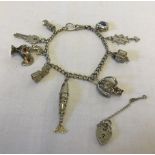 An antique silver watch chain used as a charm bracelet with 9 silver/white metal charms.
