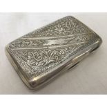 A small silver ladies cigarette case with engraved floral and scroll decoration to front and back.