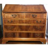 A vintage walnut veneer front 5 drawer bureau with drop down handles.