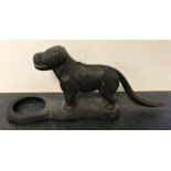 A vintage cast iron nutcracker in the shape of a dog.