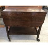 A small dark oak dual action lift drop leaf tea trolley.