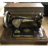 An early 20th century wooden cased Singer sewing machine complete with key.