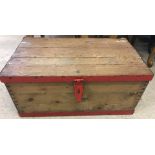 A vintage pine tool chest with red painted metal banding.