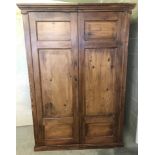 A vintage pine double door wardrobe with internal hanging rail and shelf.
