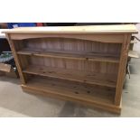 A natural finish modern pine bookcase with column detail to front.