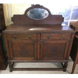 A vintage mirror backed dark wood sideboard with turned legs.