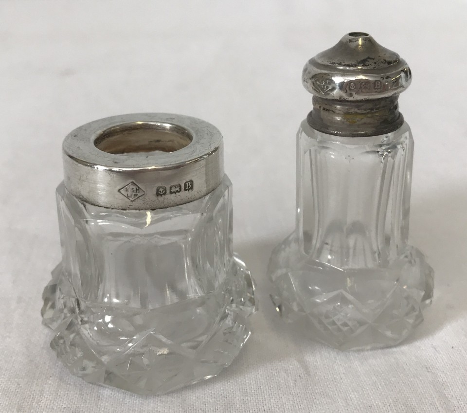 A cut glass silver topped salt pot together with a matching toothpick holder with silver rim.