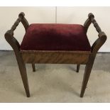 An Edwardian dark wood piano stool with tapered legs and turned handles.