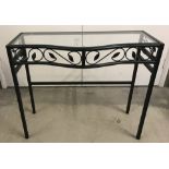 A modern wrought iron hall table / console table with glass top.