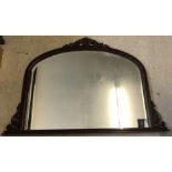 A large wooden framed over mantle mirror.