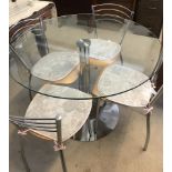 A modern circular glass top and chrome based dinning table with 4 chrome and light wood chairs.