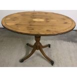 A reproduction oval topped four footed occasional table with inlaid detail.