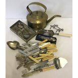 A quantity of assorted metalware and cutlery to include kettle, crumb tray and silver spoons.