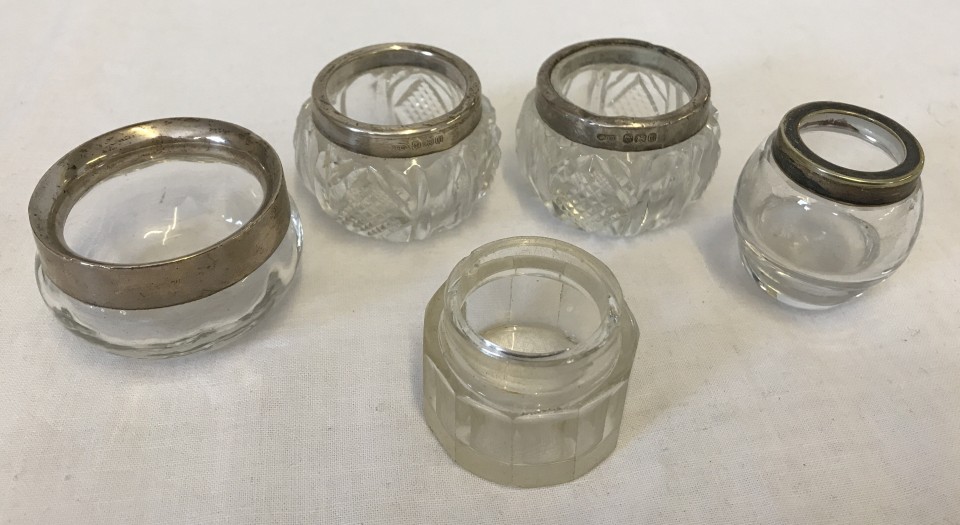 A small collection of silver rimmed salts and pots.