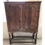 A stripped oak 2 door oak cabinet on turned legs.