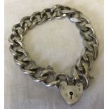 A silver large link charm bracelet with padlock and safety chain.