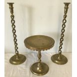 A pair of brass barley twist candle sticks together with a heavy brass circular topped stand.