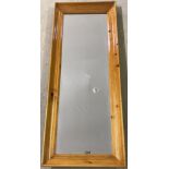 A modern rectangular pine framed wall hanging mirror.