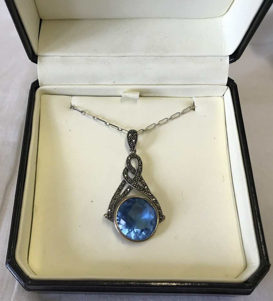 A large 925 silver drop pendant set with a blue stone and marcasites on a 18 inch silver chain.