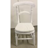 A vintage wooden child's chair with wooden seat, painted white.