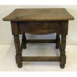 An early dark oak stool with carved detail to sides.