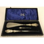 A cased silver shoe horn & button hook set.