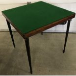 A vintage folding wooden card table with tapered legs and spade feet.