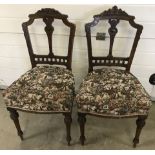 A pair of Victorian bedroom chairs with carved backs and turned front legs.
