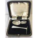 A cased baby's silver feeding spoon and pusher.