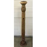 A large wooden candle holder with carved pedestal.